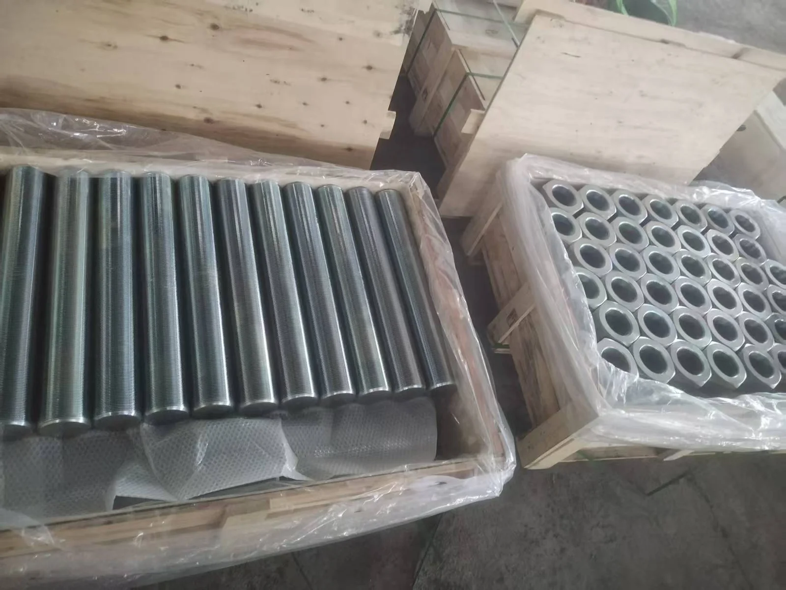 Plain-finish B7 full-thread studs and matching 2H heavy hex nuts in wooden cases before shipment to the UAE