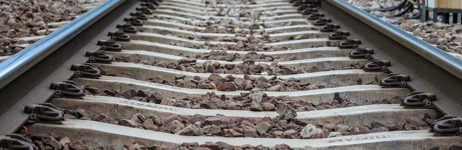 Railway track fastening system with clips on concrete sleepers